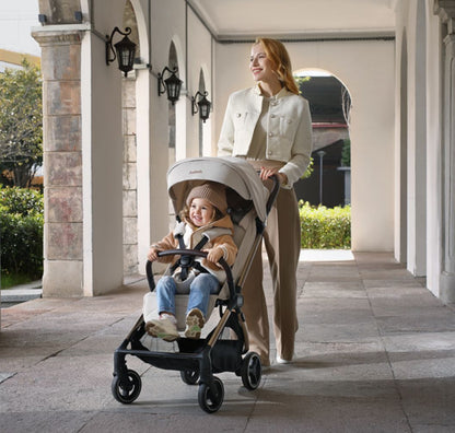 A compact stroller with a light beige canopy and seat, handlebars, and a black frame, shown on a neutral gray background with text at the top reading 'SUITABLE FROM BIRTH TO APPROX. 22KG'.