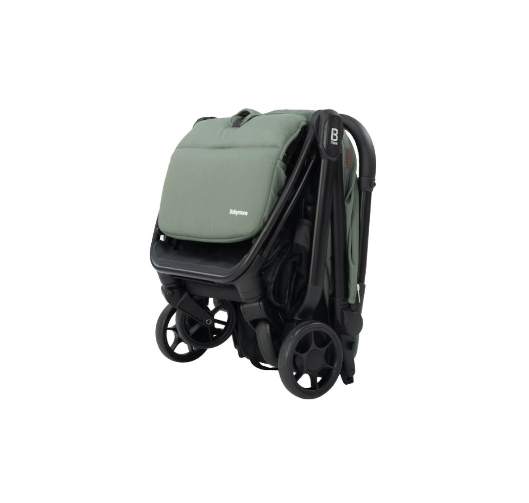 A compact stroller in sage green fabric with a black frame and wheels, shown from a three-quarters angle on a solid white background.