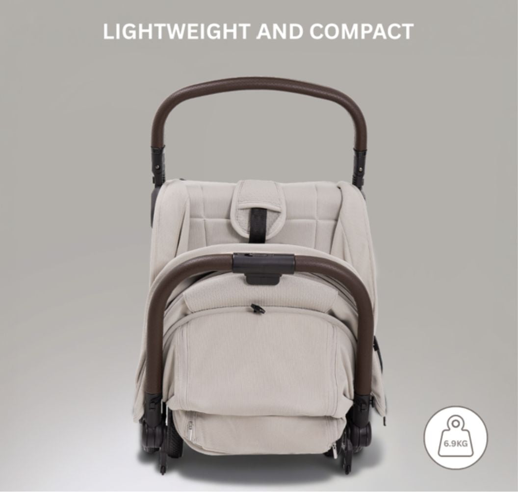 A compact stroller with a light beige canopy and seat, handlebars, and a black frame, shown on a neutral gray background with text at the top reading 'SUITABLE FROM BIRTH TO APPROX. 22KG'.
