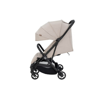 A compact stroller with a light beige (latte) canopy and seat liner, a black frame, and black wheels, shown from a three-quarters angle on a solid white background.