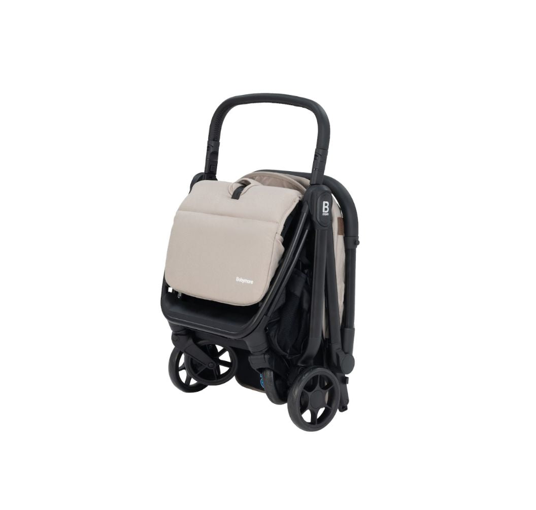 A compact stroller with a light beige (latte) canopy and seat liner, a black frame, and black wheels, shown from a three-quarters angle on a solid white background.
