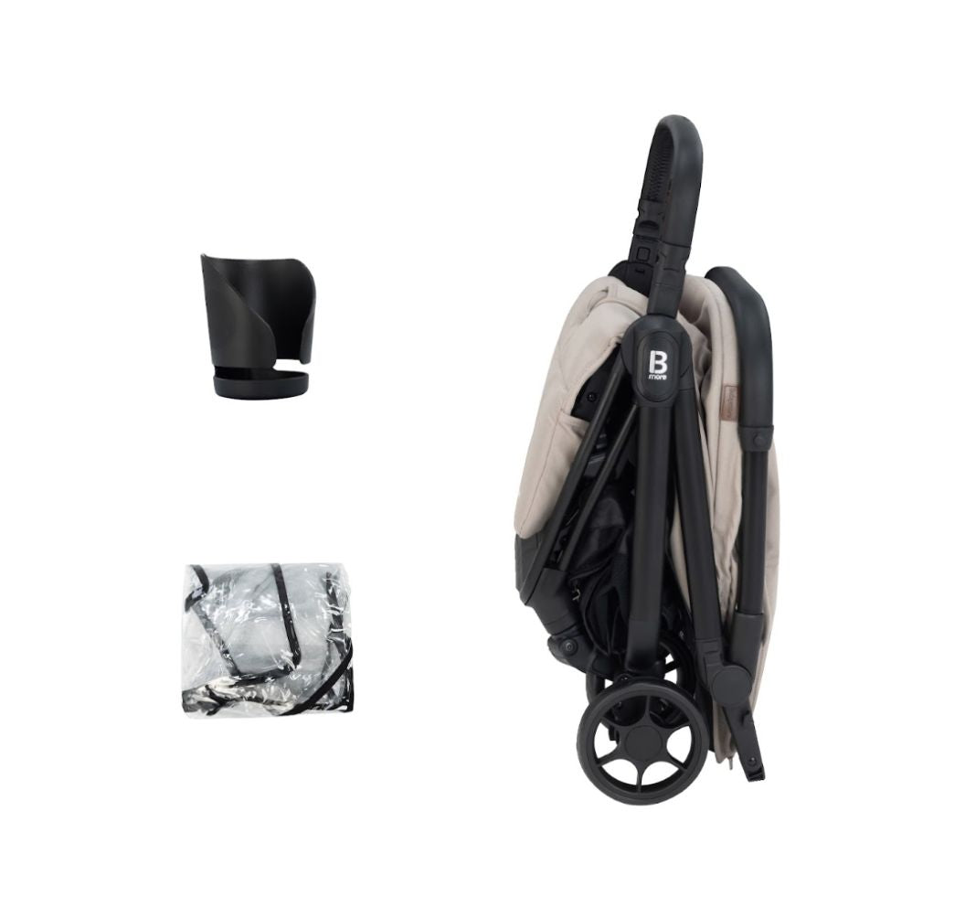 A compact stroller with a light beige (latte) canopy and seat liner, a black frame, and black wheels, shown from a three-quarters angle on a solid white background.