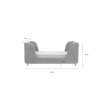 A gray upholstered children's daybed in a styled nursery or playroom with teal paneled walls, a star wall decor piece, a window with bright sunlight, a bean bag, and a basket of toys.